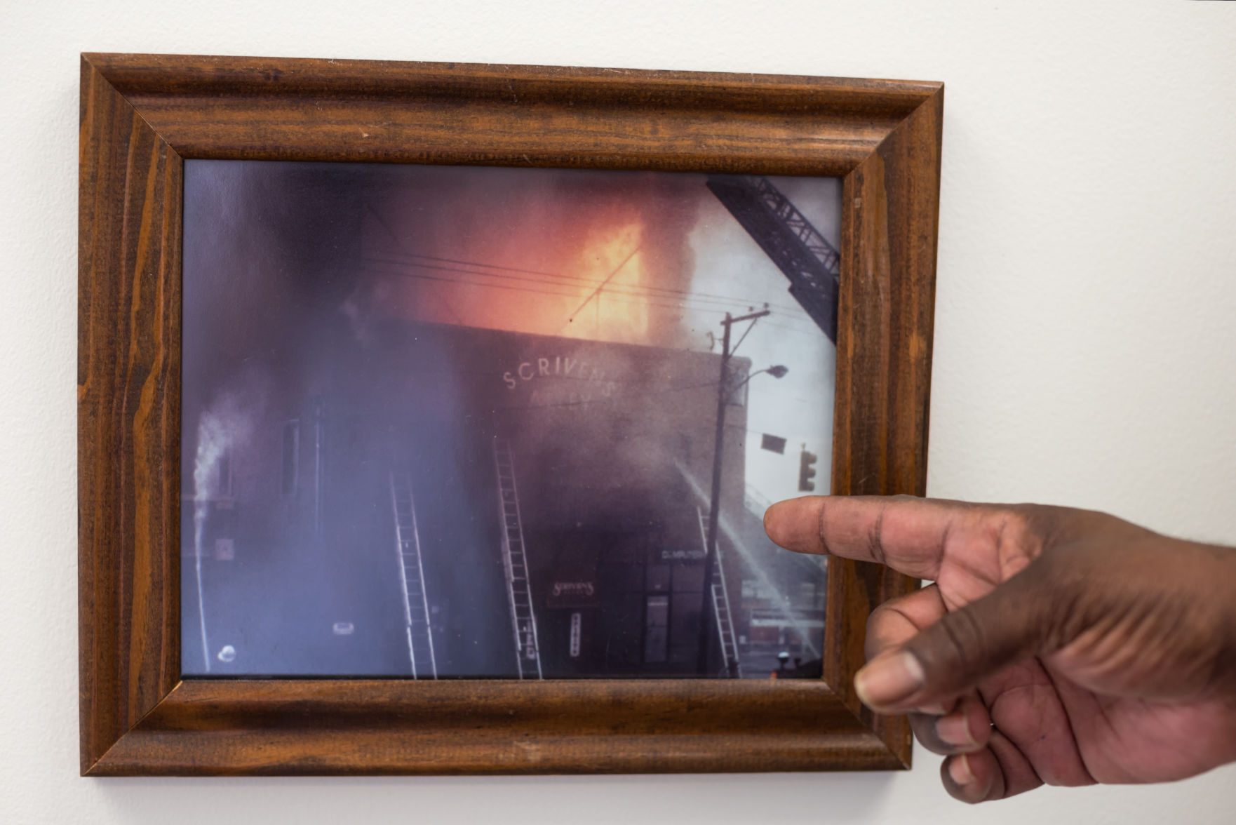 Aubrey Jenkins points to photo of Scriven's Alley fire